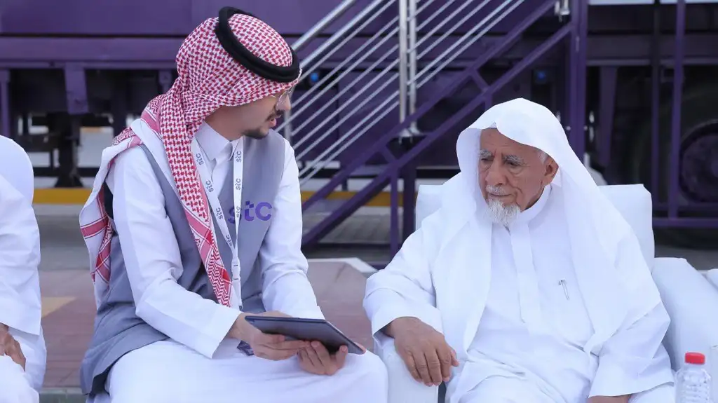 stc volunteer helping an elderly beneficiary use a tablet at the Smart Truck